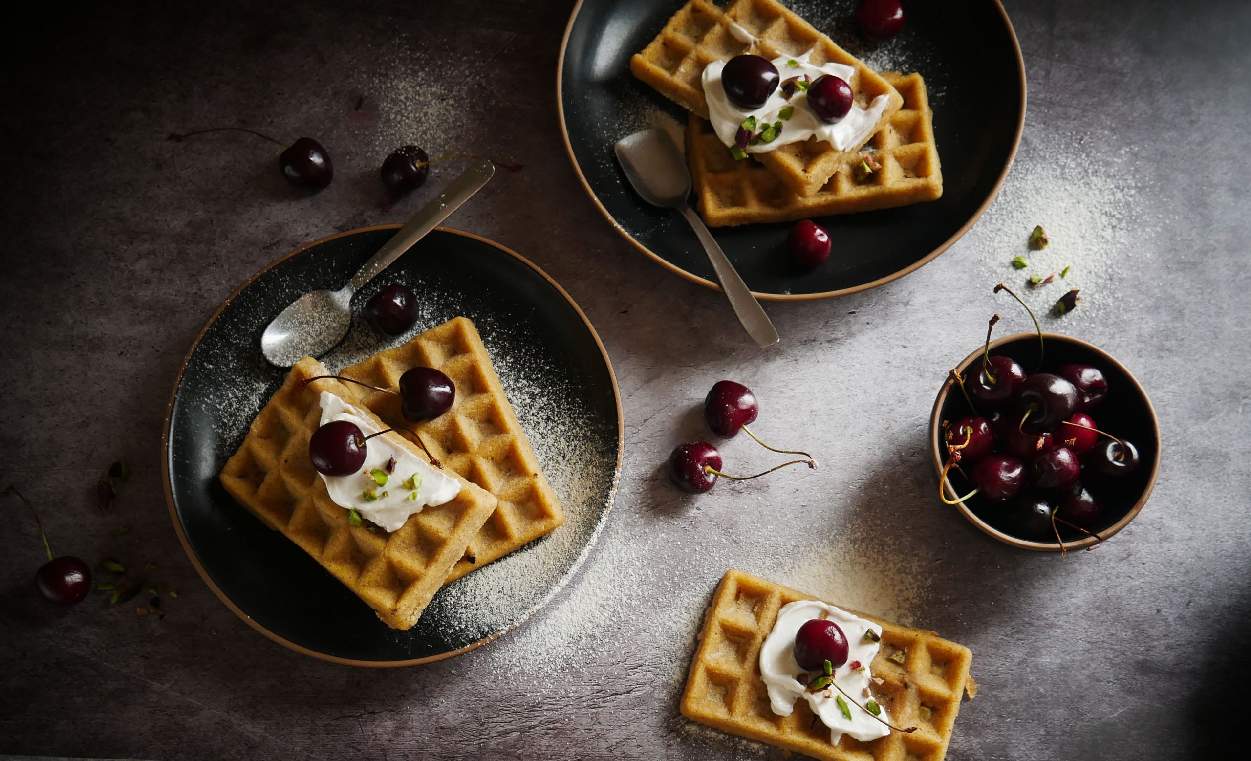 Waffles con crema alle mandorle, ciliegie e granella di pistacchi
