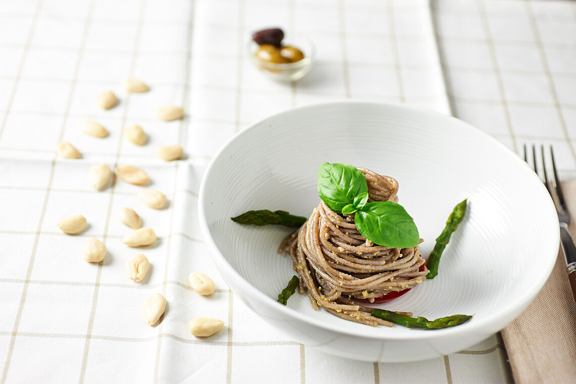 Spaghetti di grano saraceno con pesto di mandorle e olive, asparagi e basilico