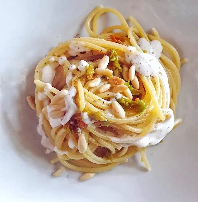 Spaghetti fiori di zucca stracciatella e pinoli
