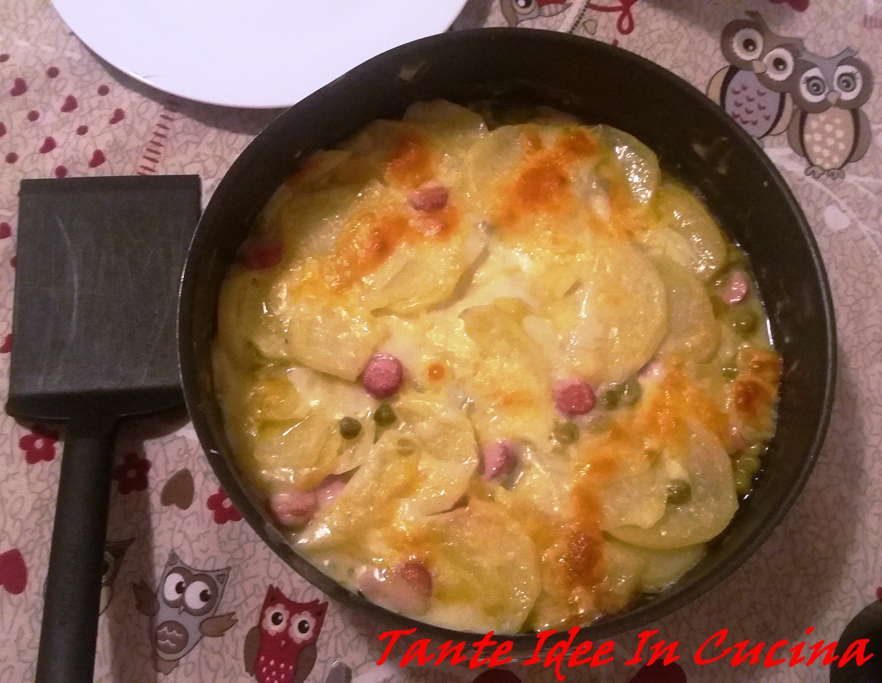 Teglia di patate con wurstel e piselli
