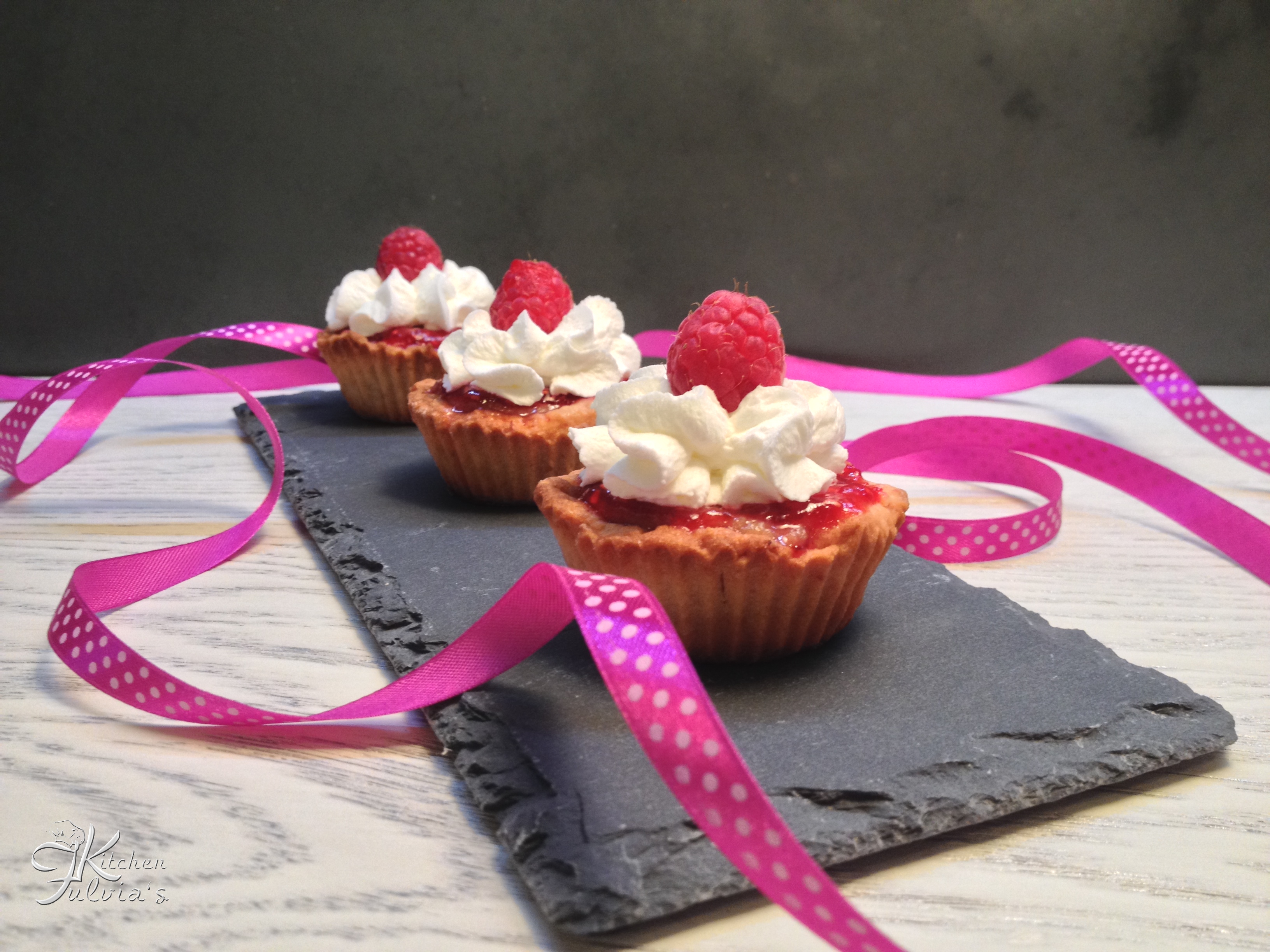 Tartellette con frolla alle fragole, crema pasticcera e coulis di lamponi