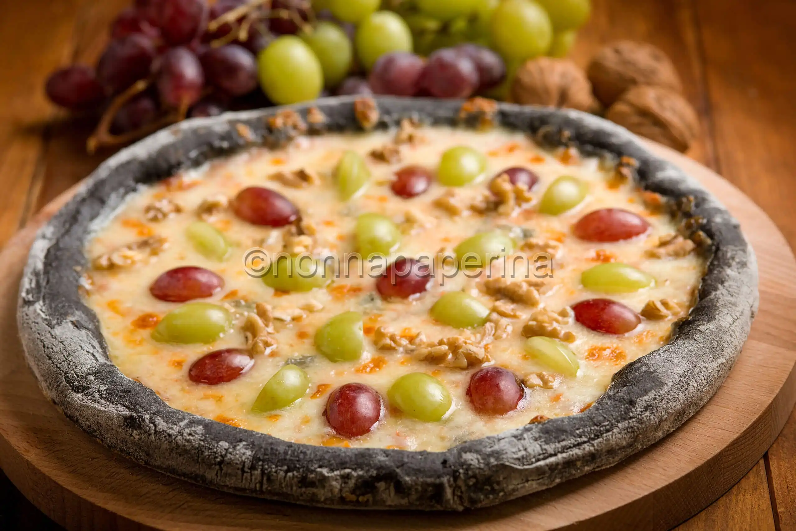 Pizza nera con uva e taleggio, un bel mix di colori e sapori